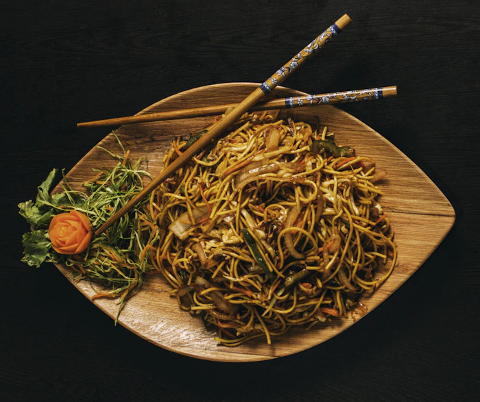 A noodle and vegetable bowl served with chopsticks