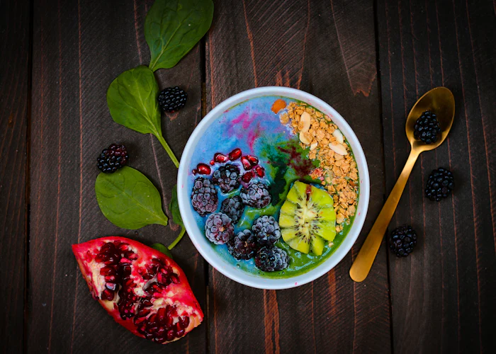 A smoothie bowl topped with fruit and seeds